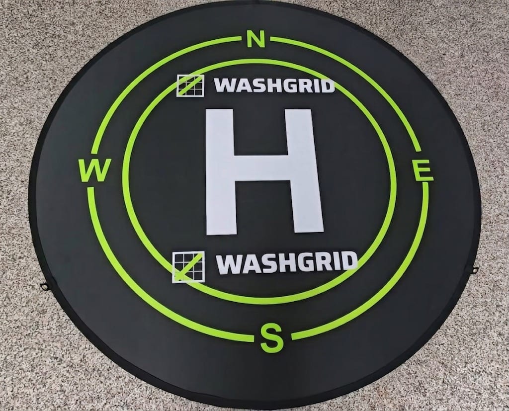 WashGrid branded drone landing pad with compass markings